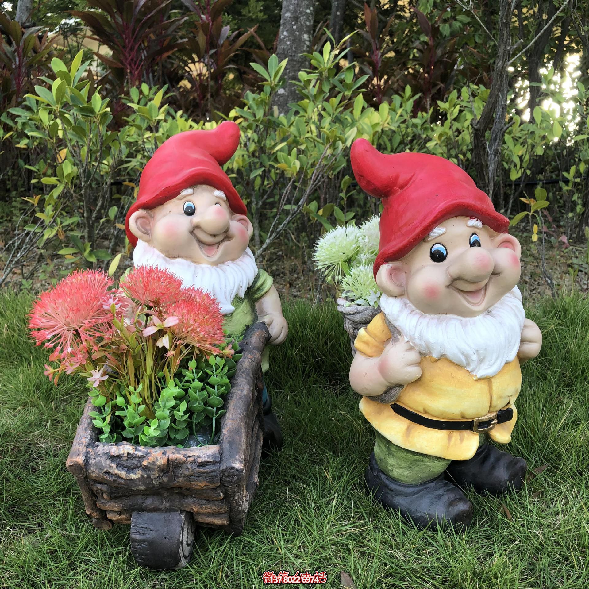 公園里擺放的一只手推花車(chē)和一個(gè)背筐的玻璃鋼卡通藍(lán)精靈雕塑